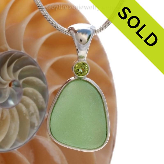 This beautiful Bright Sea Green sea glass  piece is set in our Deluxe Wire Bezel© pendant setting with a genuine Peridot gem.
Sorry this piece of Sea Glass jewelry has been SOLD!