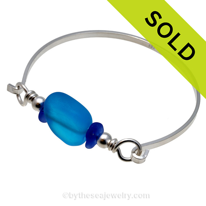 Two pieces of beach found sea glass in a blue on this solid sterling silver thin bangle sea glass bangle bracelet. 
Sorry this sea glass jewelry selection has been sold!