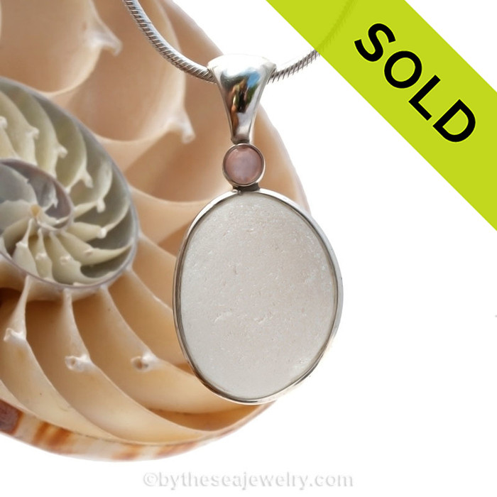 A very thick and piece of top quality pure white English sea glass pendant set with a pink mussel gem in a tube bezel setting.
Sorry this piece of Sea Glass Jewelry has been sold!