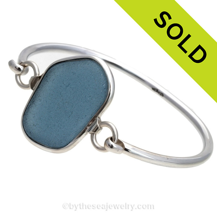 Genuine Squarish Gray Blue Sea Glass Bangle Bracelet set in our Deluxe Wire Bezel© sterling silver setting.
Sorry this piece of Sea Glass Jewelry has been sold!