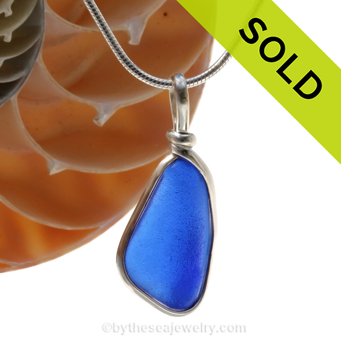 A curvy piece of Cobalt Blue Genuine Sea Glass with in our signature Original Wire Bezel© pendant setting in Sterling Silver.
Sorry this piece of sea glass jewelry has been SOLD!