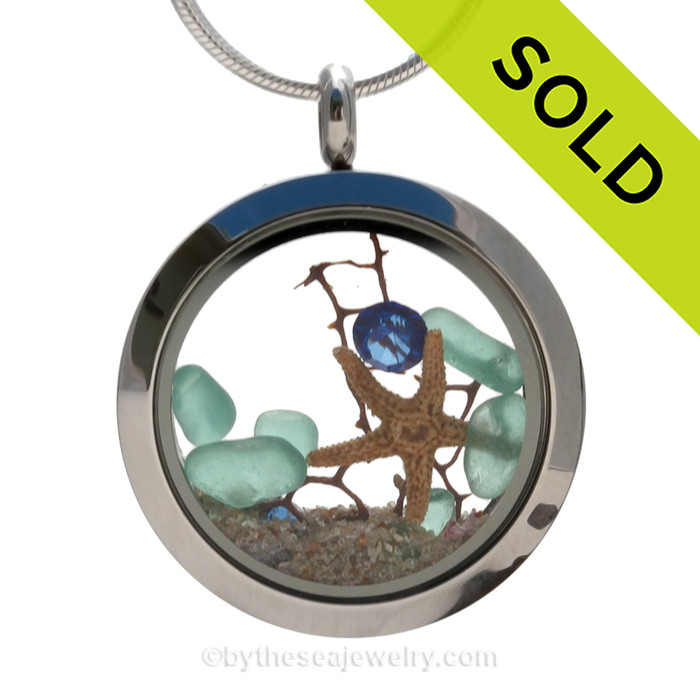 Beautiful aqua sea glass combined in a stainless steel locket necklace with a real starfish, a bit of vintage seafan and a sapphire crystal gem. Finished with real beach sand. 
SOLD - Sorry this Sea Glass Locket is NO LONGER AVAILABLE!