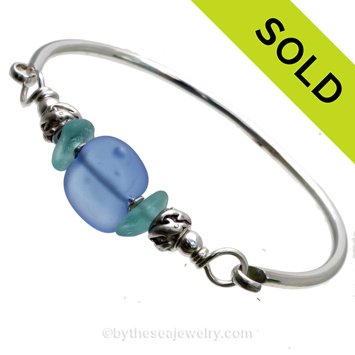 VIVID Aqua Genuine Sea Glass Bangle Bracelet set with a handmade lampwork glass bead in bright blue wet with sterling dolphin beads on a solid sterling full round bangle bracelet.
SOLD - Sorry this Sea Glass Bangle Bracelet is NO LONGER AVAILABLE!