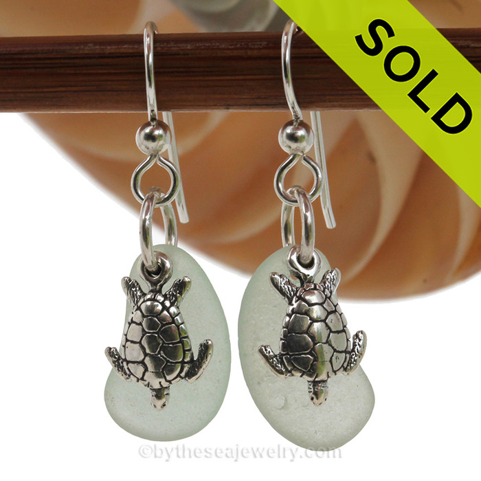 Natural bright green sea glass pieces are set with solid sterling sea turtle charms and are presented on sterling silver fishook earrings.