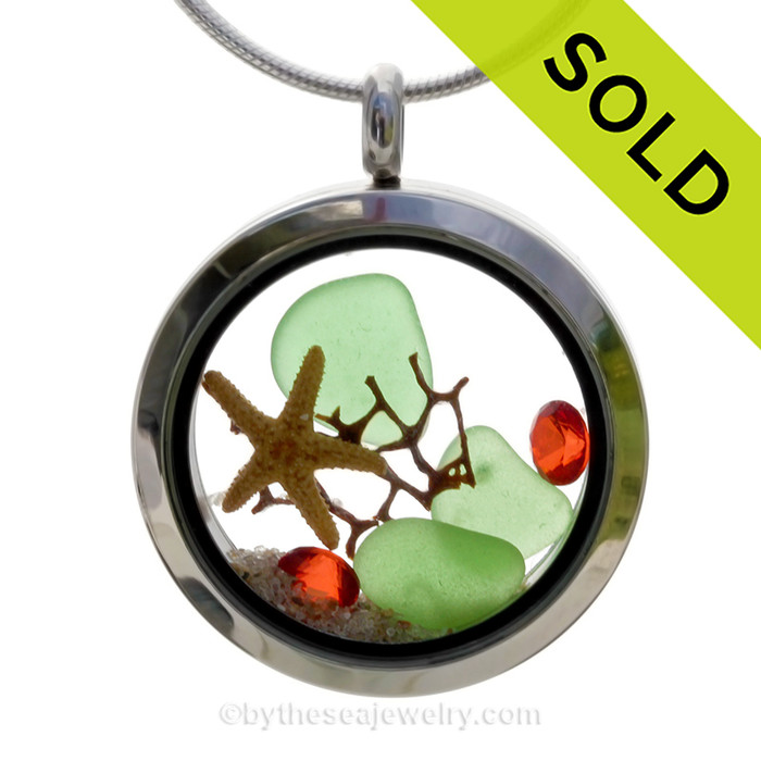 Green sea glass and a real starfish, a bit of vintage sea fan and beach sand make this a great locket necklace for the holidays.
Ruby Red  crystal gems finish the locket with some extra bling.