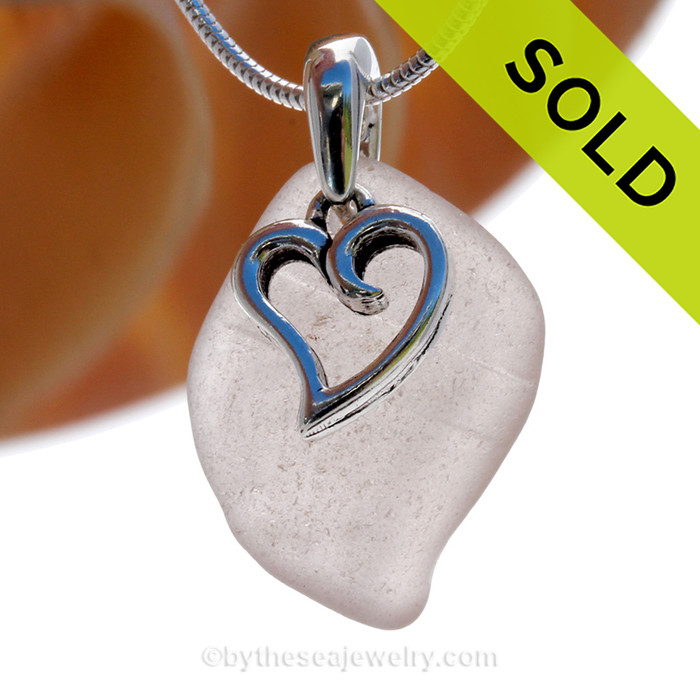 A  perfect pale ridged purple genuine sea glass with a solid sterling bail and detailed swirly heart charm.