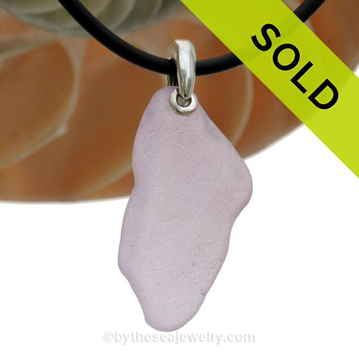 A beautiful large piece of Pale Purple Natural Sea Glass Necklace Set On Silver Bail With Black Neoprene Cord with sterling clasps.