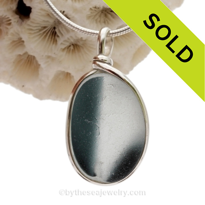 A vivid mix of Smoked Teal in a base of pure white endoday sea glass from England set in our Original Wire Bezel© necklace pendant setting.