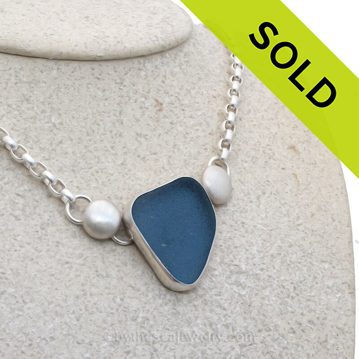 A stunning deep cornflower blue sea glass set in fine silver with sterling details on a oval rolo chain.