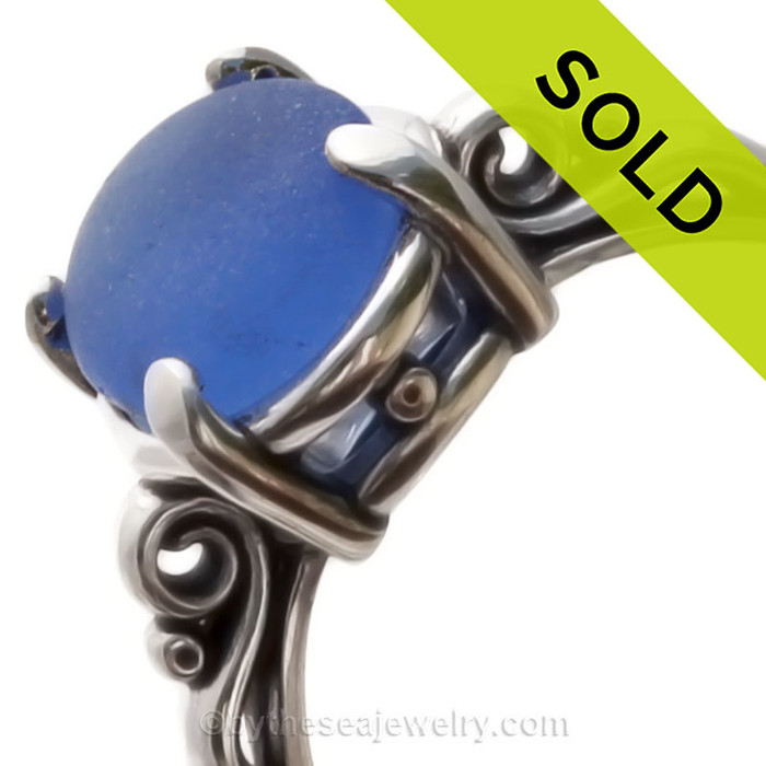 A stunning and lovely piece of PERFECT NATURAL bright Blue beach found sea glass securely set in a solid sterling silver scroll ring. 