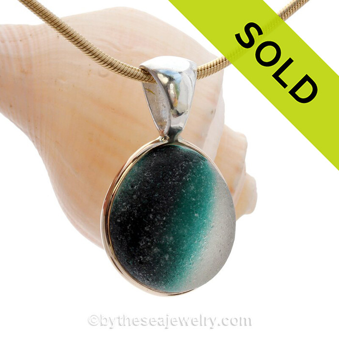 This sea glass is fused through with vivid teal green color and set in a mixed metal gold and sterling silver Deluxe Wire Bezel setting. This setting leaves this amazing natural sea glass piece just the way it was found on the beach!