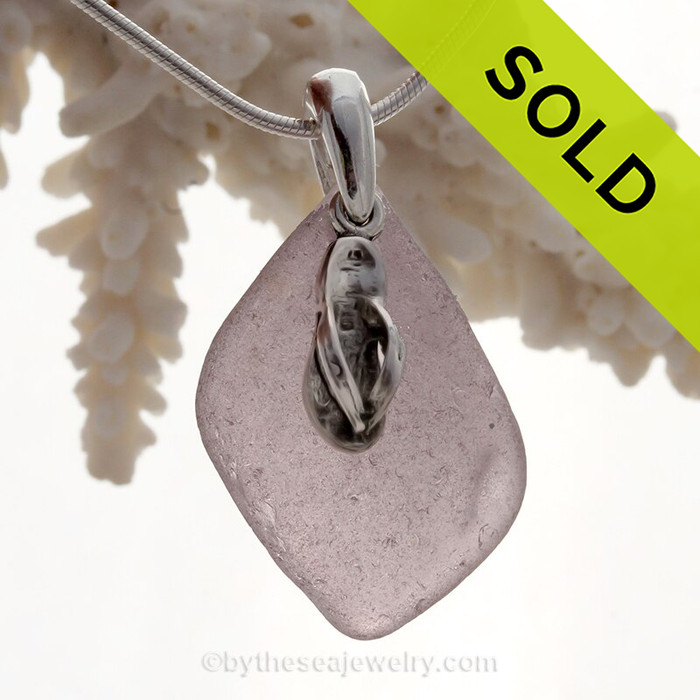 A perfect piece of Deep Purple Certified Genuine Sea Glass in a sterling necklace with a flip flop charm.
Solid Sterling professionally hand cast bail.
Stunning Purple Sun Glass from the Island of Betsy Wyeth in Maine.