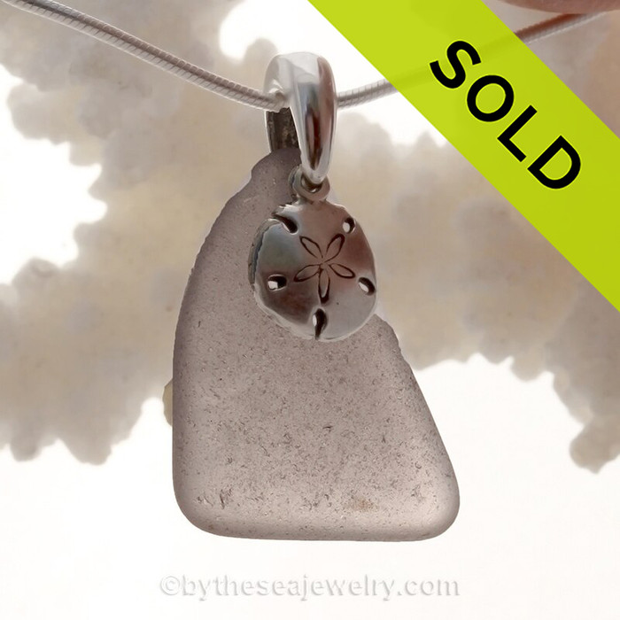 A perfect piece of Deep Purple Certified Genuine Sea Glass in a sterling necklace with a Sandollar charm.
Solid Sterling professionally hand cast bail.
Stunning Purple Sun Glass from the Island of Betsy Wyeth in Maine.
