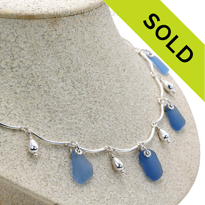 5 pieces of Light Blue Genuine Beach Collected Sea Glass on a Solid Sterling Silver Curved Bar Necklace with Sterling Beautiful Sterling Teardrop Beads in a elegant necklace.
