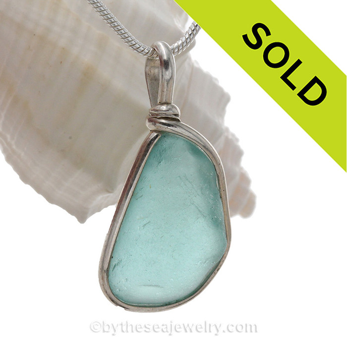 A lovely piece of beach found glass from Seaham England in a stunning aqua blue is set in our Original Wire Bezel© pendant setting.