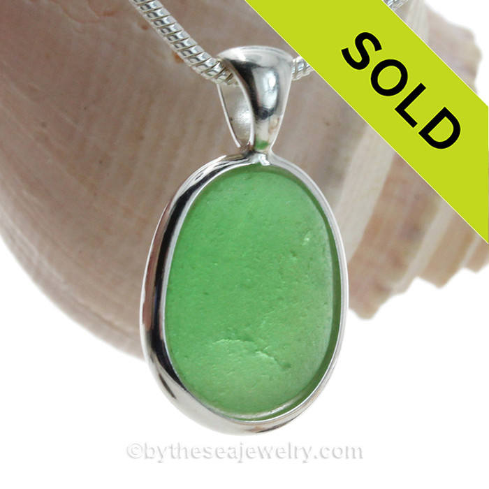 A nice piece of bright green sea glass in an elegant and versatile setting.
Done in our Deluxe Wire Bezel© setting that leaves both front and back open for maximum color. Fully Reversible!