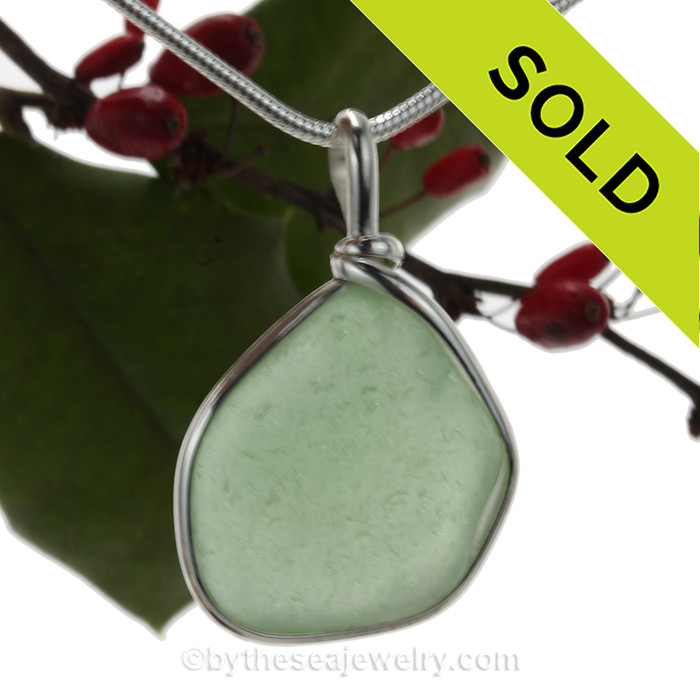 A Lovely Bright and Fresh Sea Green beach found glass from is set in our Original Wire Bezel© pendant setting in sterling silver