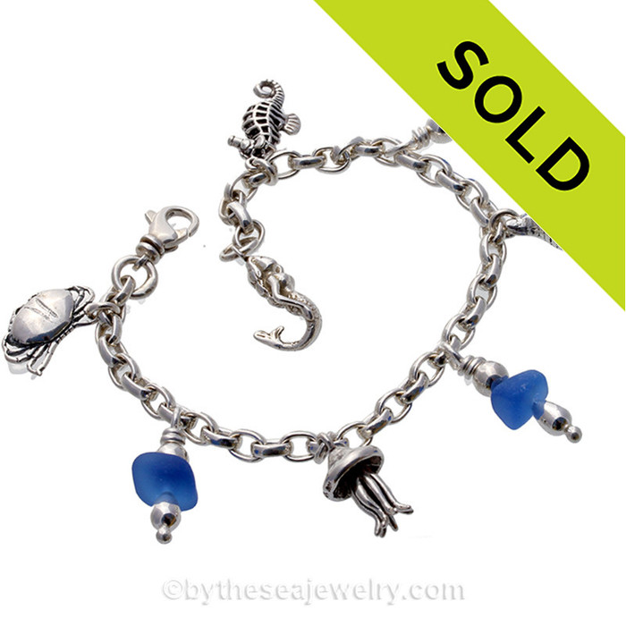 3 pieces of vivid medium blue sea glass from England on a solid 4.2 mm chain. 
This glass is Certified Genuine Sea Glass and comes on a fully soldered seamless bracelet with soldered utility links. Adjustable from 7-8 inches by use of an extra utility clasp 1 inch in from the mermaid charm.
