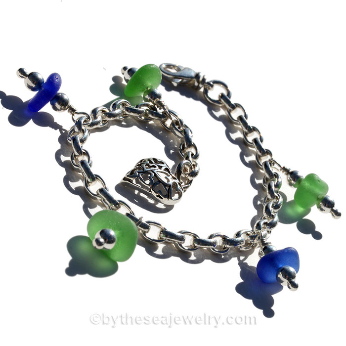 5 pieces of jsea glass in greens and blue on a solid sterling silver bracelet.