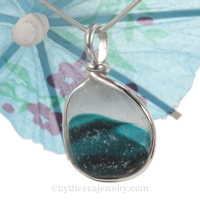 An amazing combination of  mixed aqua medium blue in this very old English Sea Glass piece and set in our Original Wire Bezel© necklace pendant setting. The coloring in the glass resembles a wave! BEAUTIFUL!