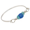 Vivid aqua sea glass pieces and a handmade center bead of bright blue set with sterling details on a thin solid sterling flat bangle bracelet.