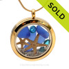 A gold tone stainless steel locket necklace with real blue beach found sea glass pieces and two real starfish and finished with Turquoise crystal gems.