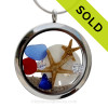 Cobalt Blue and a small piece of Ruby Red Sea Glass in a crystal and stainless steel locket combined with two  baby starfish, sandollar and crystal gems.  
SOLD - Sorry This Sea Glass Jewelry Item is NO LONGER AVAILABLE!