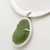 A huge piece of olive green sea glass from England set in a custom made cage. The sea glass is held secure front and back with soldered prongs. 

Picture on 10MM Omega Necklace (INCLUDED - a $140 value).