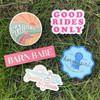Assorted equestrian stickers with horse sayings and western-inspired designs displayed on grass