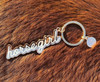 Horse girl script keychain with gold-tone ring displayed on brown textured background