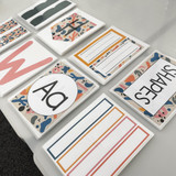 Printed Retro Brights classroom printables laid out on a table, including labels and posters