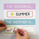Pastel weather and seasons whiteboard clings held up to show the reusable static cling