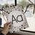 Hand holding a printed Modern Terrazzo Aa alphabet poster by a classroom window