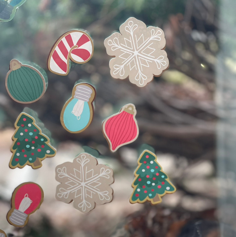 Christmas cookie clings of trees, snowflakes, and ornaments on a window