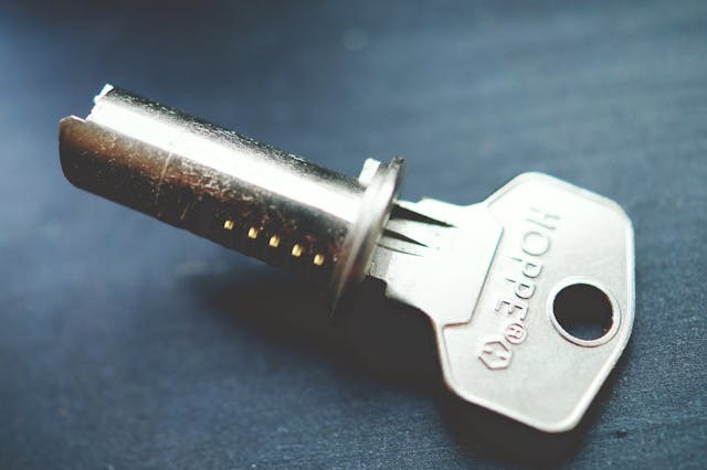 Stainless steel key inside a cylinder on a table