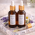 Two amber glass dropper bottles of Lavender and Chamomile Hair Oil from The Ginger Goats, displayed on a crystal-style tray with a pipette, lavender sprigs and chamomile flowers in a soft, calming setting.