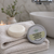 Natural Rice Water Coconut and Rosemary shampoo bar resting on folded towels beside its tin packaging in a calm bathroom setting, showing an eco-friendly solid shampoo for healthy, clean hair.