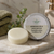 Natural avocado and shea butter conditioner bar for deep nourishment displayed in a spa-style bathroom setting with Ginger Goats tin.