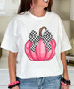 pink pumpkin with black and white checkered bow tee close up