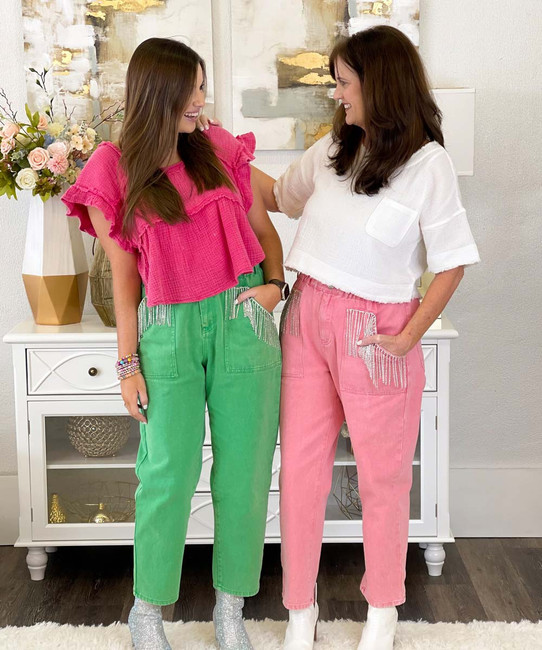 Happy Joyful Kid In Trendy Casual Outfit Puts Pink Bucket Hat On Her Head.  Cheerful Beautiful Black Girl Wearing Loose Fuchsia Top And Green Pants  Having Fun And Laughing. Childrens Fashion Concept