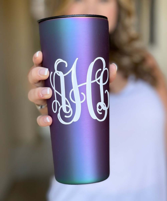 A young woman holding a monogrammed tumbler