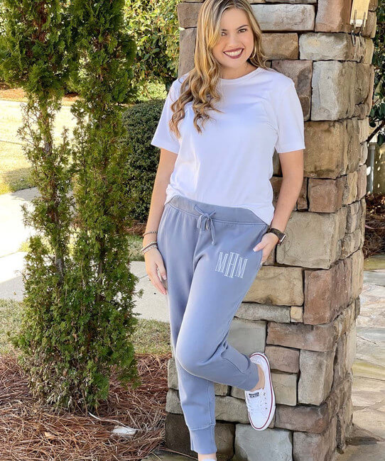 A young woman wearing monogrammed joggers