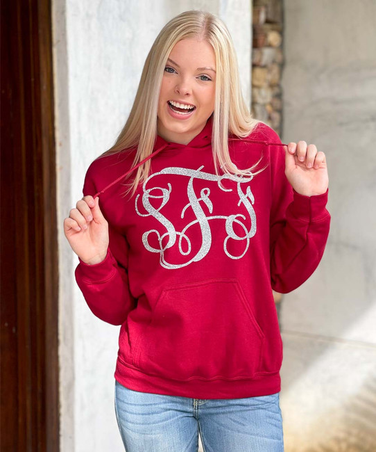 A young woman wearing a monogrammed sweatshirt