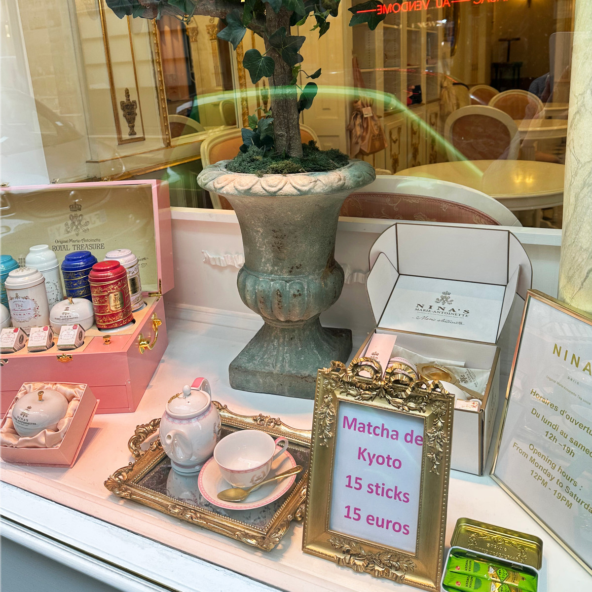 Tea tins, porcelain, and sweet treats fill the window display at Nina's Marie-Antoinette, where signature blends are inspired by the flavours said to have been favoured by Marie-Antoinette herself, including rose, apple, and delicate floral notes.