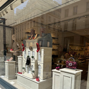On Rue du Faubourg Saint-Honoré, even the shop windows become miniature worlds. This playful display from Maison Vivier transforms Parisian architecture into fashion theatre, where shoes and accessories appear to inhabit their own elegant hôtel particulier.