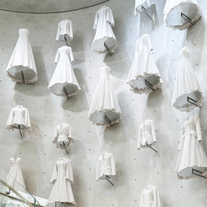 White couture dresses displayed inside Dior 30 Avenue Montaigne in Paris
