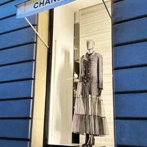 A softly illuminated evening silhouette displayed at Chanel in Paris, where delicate textures and couture-inspired detailing embody the maison’s enduring vision of femininity.