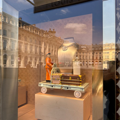 Louis Vuitton and Place Vendôme in Reflection
A Louis Vuitton display becomes part of the square itself as the façades of Place Vendôme reflect across the glass. Jewellery, travel trunks and Parisian architecture merge into a single scene — a reminder that on Place Vendôme, luxury rarely exists in isolation from its surroundings.