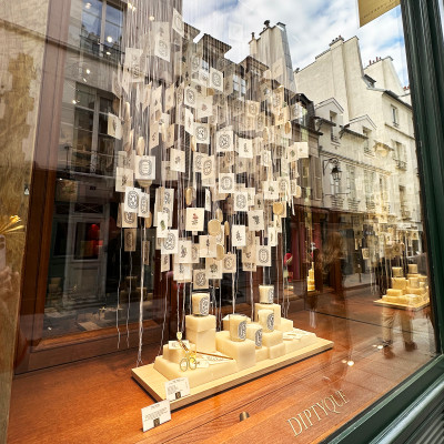 Elegant window displays and iconic French fragrance houses add to the refined shopping experience along Rue des Francs-Bourgeois.