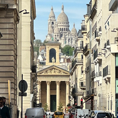 Looking west along Boulevard Haussmann, the white domes of Sacré-Cœur rise above the rooftops of Montmartre, creating one of the boulevard's most beautiful long-distance views.